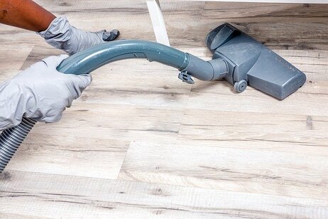 Picture of a person using a cleaning machine to clean hardwood floor